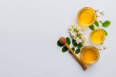 Akasya çiçekli ve yapraklı bal kavanozu. Taze bal üst görünüm düz yatıyordu.