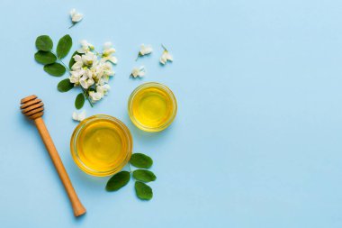 Akasya çiçekli ve yapraklı bal kavanozu. Taze bal üst görünüm düz yatıyordu.