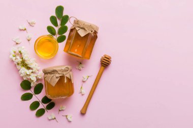 Akasya çiçekli ve yapraklı bal kavanozu. Taze bal üst görünüm düz yatıyordu.