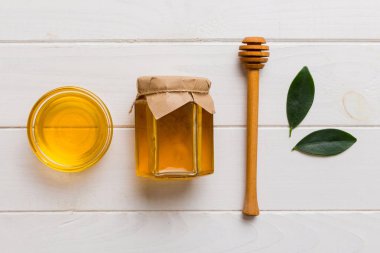 Bal kavanozu, beyaz arka plan manzaralı ve fotokopi alanı olan ahşap bal kaplama. Lezzetli bal şişesi.