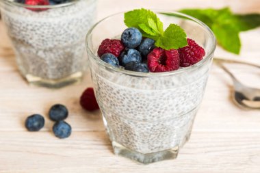Sağlıklı kahvaltı ya da sabah chia tohumlu vanilyalı puding ahududu ve böğürtlen, vejetaryen gıda, diyet ve sağlık konsepti. Ahududu ve yabanmersinli Chia pudingi..