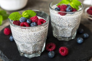 Sağlıklı kahvaltı ya da sabah chia tohumlu vanilyalı puding ahududu ve böğürtlen, vejetaryen gıda, diyet ve sağlık konsepti. Ahududu ve yabanmersinli Chia pudingi..