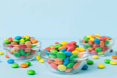 Renkli arka planda bir kasede çok renkli şekerler. Doğum günü ve tatil konsepti. Kopyalama alanı olan üst görünüm.