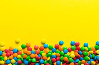 Renkli arka planda karışık renkli şeker koleksiyonu. Düz yerde, üst tarafta. Renkli çikolata kaplı şeker çerçevesi.