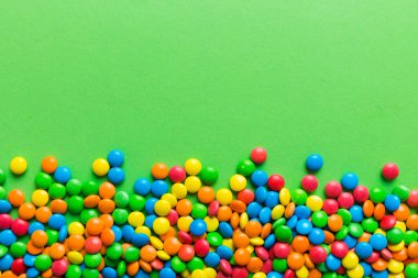 Renkli arka planda karışık renkli şeker koleksiyonu. Düz yerde, üst tarafta. Renkli çikolata kaplı şeker çerçevesi.