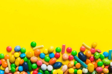 Renkli arka planda karışık renkli şeker koleksiyonu. Düz yerde, üst tarafta. Renkli çikolata kaplı şeker çerçevesi.