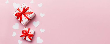 Sevgililer Günü kompozisyonu: Yay ve kalple kırmızı hediye kutusu. Noel hediyesi. Yukarıdan bak. Mesaj için yer var. Holday tebrik kartı.