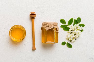 Akasya çiçekli ve yapraklı bal kavanozu. Taze bal üst görünüm düz yatıyordu.