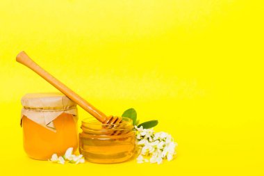 robinia honey bollte with acacacia flomes on color table.