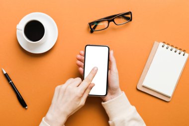 Mesajınız veya bilgi içeriğiniz için boş bir kopya ekranı olan akıllı telefonları tutan kadın ellerinin üst görünümü. üst görünümde telefon beyaz ekranı kullanan kadın eli.