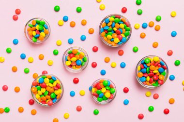 farklı renkte yuvarlak şekerler ve kavanozlar. Fotokopi alanı olan büyük çeşitlilikteki şeker ve şekerlerin üst görünümü.