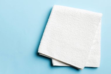 Renkli arkaplanda kopyalama alanı olan beyaz havluların üst görünümü.