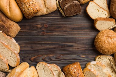 Ev yapımı doğal ekmek. Arka plan olarak farklı taze ekmek türleri, kopya alanı ile üst görünüm.