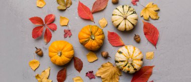 Sonbahar kompozisyonu. Masadaki kurumuş yapraklar ve diğer tasarım aksesuarlarından oluşan desen. Düz yatış, üst görünüm.