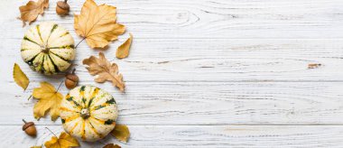 Sonbahar kompozisyonu. Masadaki kurumuş yapraklar ve diğer tasarım aksesuarlarından oluşan desen. Düz yatış, üst görünüm.