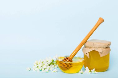 robinia honey bollte with acacacia flomes on color table.