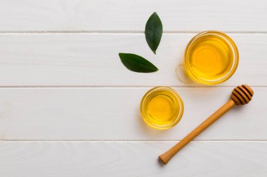 Bal kavanozu, beyaz arka plan manzaralı ve fotokopi alanı olan ahşap bal kaplama. Lezzetli bal şişesi.