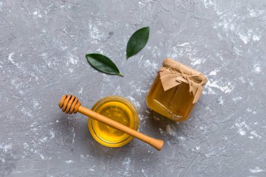 Bal kavanozu, beyaz arka plan manzaralı ve fotokopi alanı olan ahşap bal kaplama. Lezzetli bal şişesi.