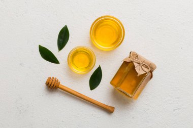 Bal kavanozu, beyaz arka plan manzaralı ve fotokopi alanı olan ahşap bal kaplama. Lezzetli bal şişesi.