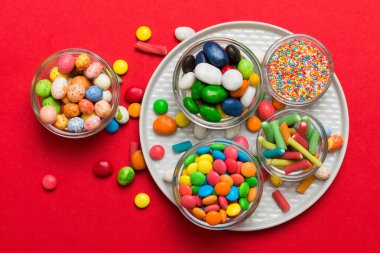 farklı renkte yuvarlak şekerler ve kavanozlar. Fotokopi alanı olan büyük çeşitlilikteki şeker ve şekerlerin üst görünümü.