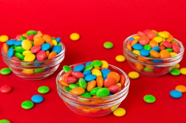 Renkli arka planda bir kasede çok renkli şekerler. Doğum günü ve tatil konsepti. Kopyalama alanı olan üst görünüm.