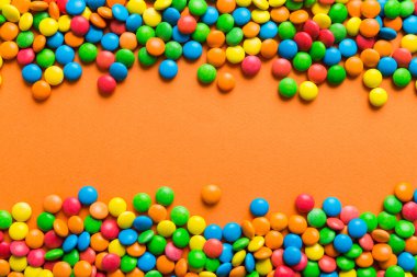 Renkli arka planda karışık renkli şeker koleksiyonu. Düz yerde, üst tarafta. Renkli çikolata kaplı şeker çerçevesi.