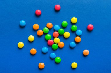 Renkli arka planda karışık renkli şeker koleksiyonu. Düz yerde, üst tarafta. Renkli çikolata kaplı şeker çerçevesi.