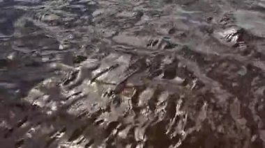 Nehrin yüzeyinde dalgalar. Soyut doğal sıvı yüzey arkaplanı. Güzel, huzurlu, güneşli, güneşli, deniz suyu arka planı..