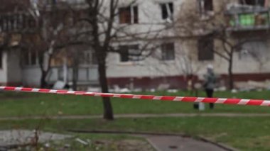 Kırmızı-beyaz bariyer bandının arka planında yürüyen insanların siluetleri. Kırmızı ve beyaz bariyer bandı yayalar ve insanlar için tehlikeli bir yer olduğunu gösteriyor..