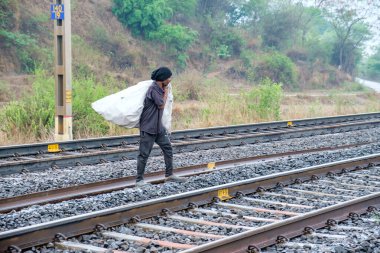 Pune, Hindistan - 07 Mayıs 2023: Pune Hindistan yakınlarındaki Kamshet 'te bir plastik çuval taşıyan adam.