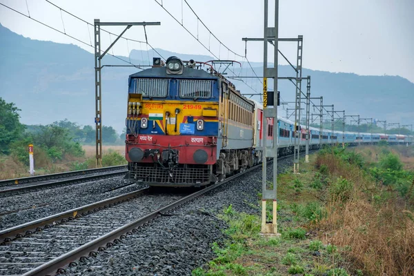 stock image Pune, India - May 07 2023: A passenger train hauled by a WCAM3 electric locomotive at Kamshet near Pune India.