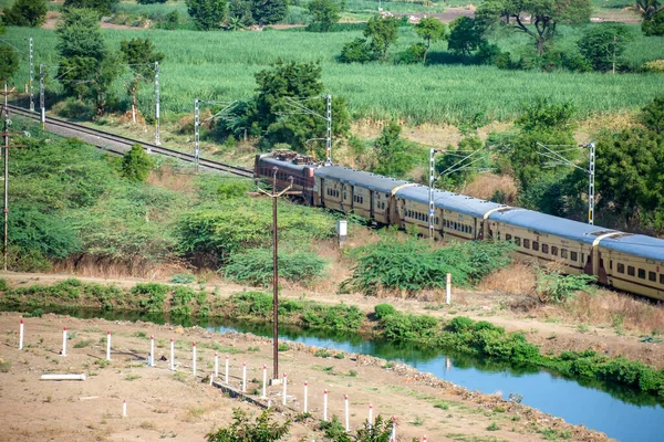 Pune, Hindistan - 14 Mayıs 2023: Pune Hindistan yakınlarındaki Uruli 'de WAP4 Electric lokomotifi tarafından taşınan yolcu treni.