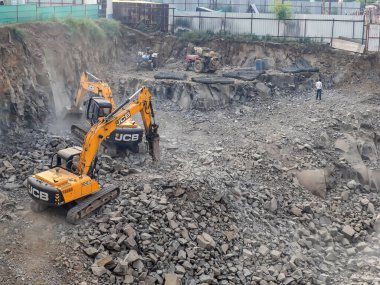 Pune, Hindistan - 09 Ekim 2022: Pune Hindistan 'daki bir inşaat alanında bir toprak kazıcı makine.