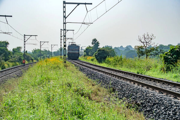 Пуна, Индия - 08 октября 2023 года: Пассажирский поезд, перевозимый электровозом WAP4 недалеко от Пуны, Индия.