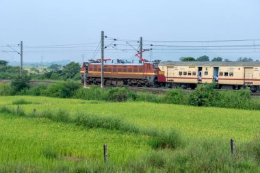 Pune, Hindistan - 14 Ekim 2023: Pune Hindistan yakınlarında WAP4 elektrikli bir lokomotif tarafından taşınan yolcu treni.