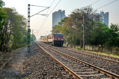 Pune, Hindistan - 09 Nisan 2023: Pune Hindistan yakınlarında WAP4 elektrikli bir lokomotif tarafından taşınan yolcu treni.