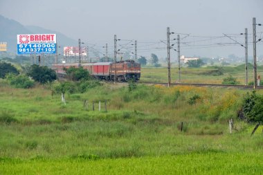 Pune, Hindistan - 14 Ekim 2023: Pune Hindistan yakınlarında WAP4 elektrikli bir lokomotif tarafından taşınan yolcu treni.