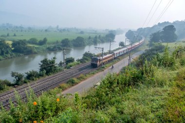 Pune, Hindistan - 15 Ekim 2023: Pune Hindistan yakınlarında WAP4 elektrikli bir lokomotif tarafından taşınan yolcu treni.