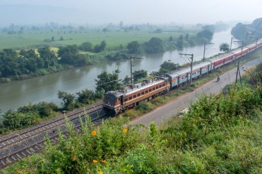 Pune, Hindistan - 15 Ekim 2023: Pune Hindistan yakınlarında WAP4 elektrikli bir lokomotif tarafından taşınan yolcu treni.