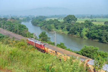 Pune, Hindistan - 15 Ekim 2023: Pune Hindistan yakınlarında WAP4 elektrikli bir lokomotif tarafından taşınan yolcu treni.
