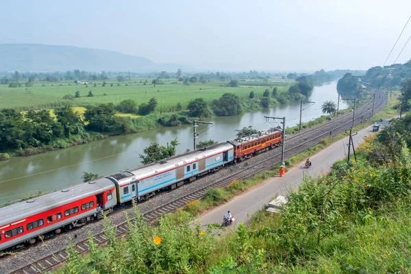 Pune, Hindistan - 15 Ekim 2023: WCAM2P elektrikli lokomotif Pune Hindistan yakınlarındaki bir yolcu trenini taşıyor.