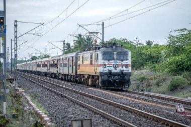 Pune, Hindistan - 09 Temmuz 2023: Pune Hindistan yakınlarında WAP7 elektrikli bir lokomotif tarafından taşınan yolcu treni.