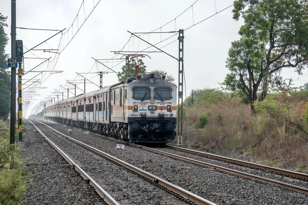 Pune, Hindistan - 18 Haziran 2023: Pune Hindistan yakınlarında WAP7 elektrikli bir lokomotif tarafından taşınan yolcu treni.