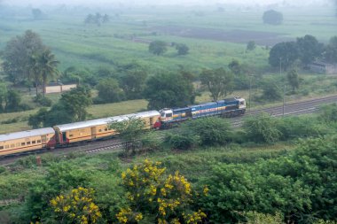 Pune, Hindistan - 22 Ekim 2023: WDP4B dizel lokomotif Pune Hindistan yakınlarında bir yolcu treni taşıyor.