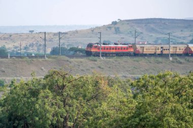Pune, Hindistan - 24 Ekim 2023: Pune Hindistan yakınlarında WAP4 elektrikli bir lokomotif tarafından taşınan yolcu treni.
