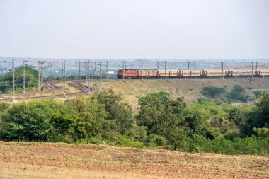 Pune, Hindistan - 24 Ekim 2023: Pune Hindistan yakınlarında WAP4 elektrikli bir lokomotif tarafından taşınan yolcu treni.