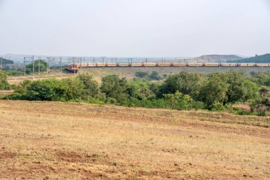 Pune, Hindistan - 24 Ekim 2023: Pune Hindistan yakınlarında WAP4 elektrikli bir lokomotif tarafından taşınan yolcu treni.