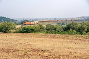 Pune, Hindistan - 24 Ekim 2023: Pune Hindistan yakınlarında WAP4 elektrikli bir lokomotif tarafından taşınan yolcu treni.