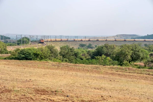 Pune, Hindistan - 24 Ekim 2023: Pune Hindistan yakınlarında WAP4 elektrikli bir lokomotif tarafından taşınan yolcu treni.