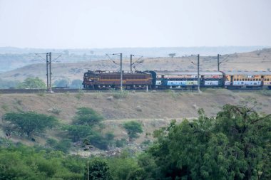 Pune, Hindistan - 24 Ekim 2023: WCAM2P elektrikli lokomotif Pune Hindistan yakınlarındaki bir yolcu trenini taşıyor.